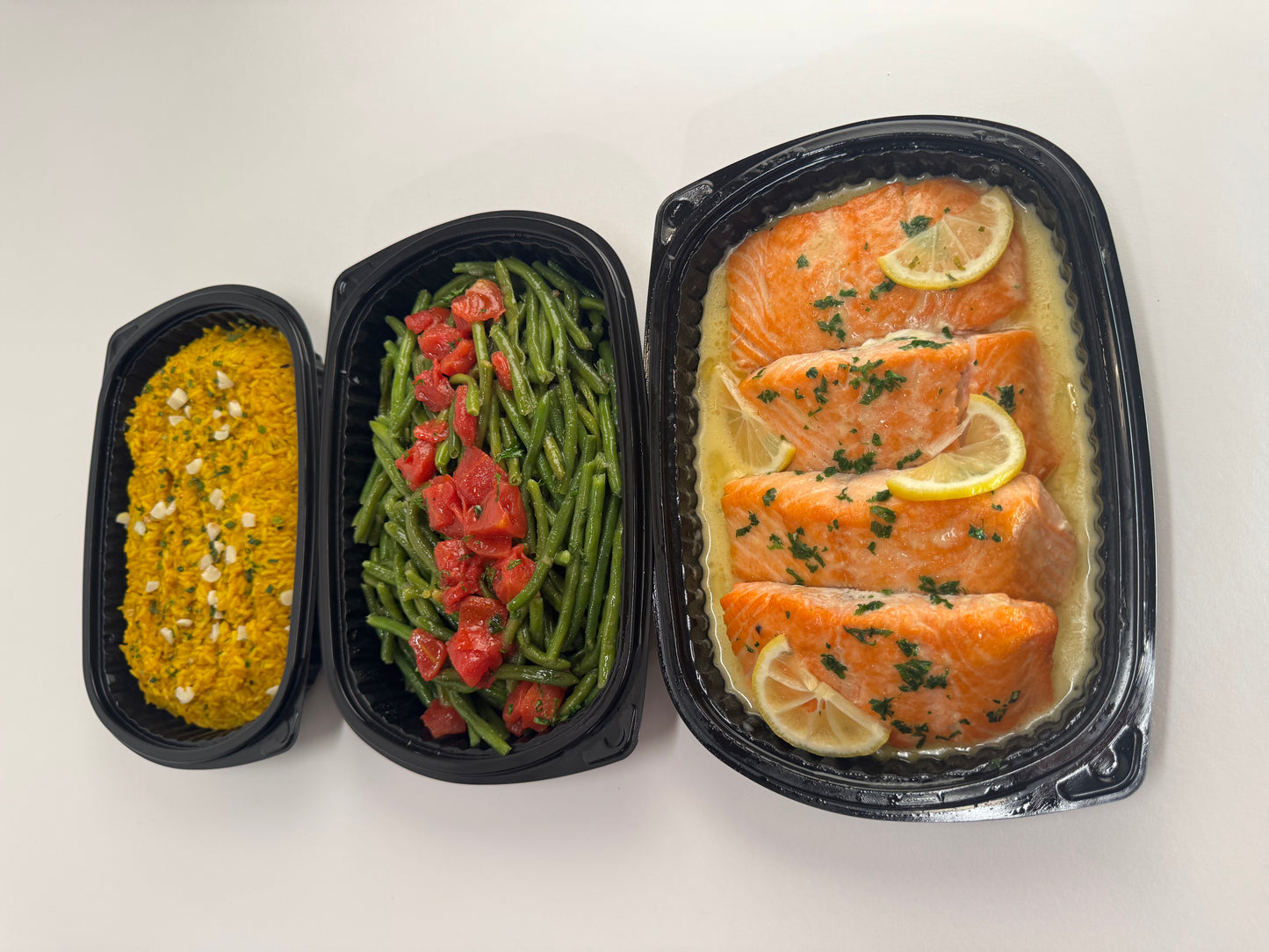 Freshly seared Salmon with lemon velouté paired with turmeric rice with pickled garlic and seasoned green beans with diced tomatoes