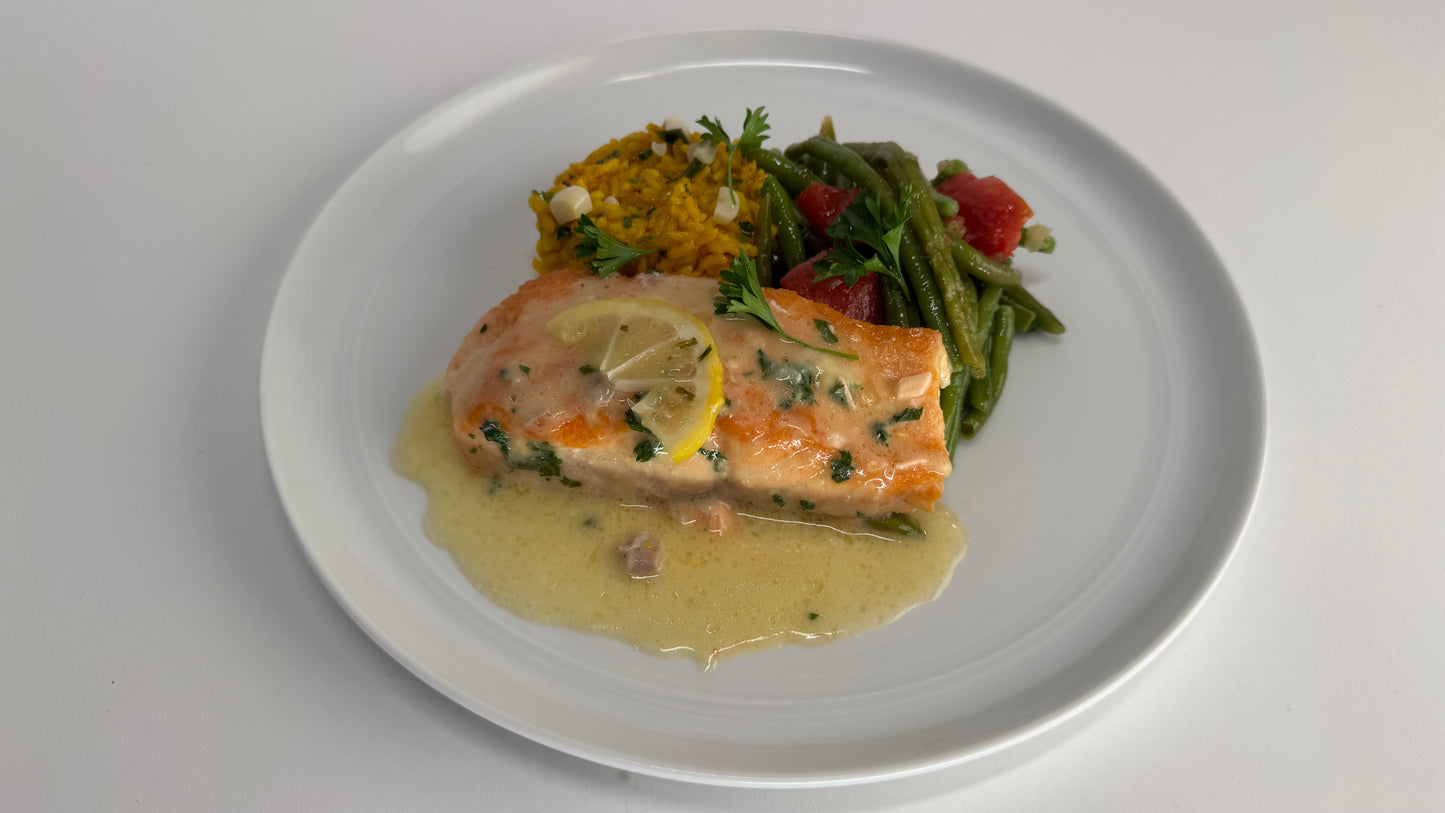 Freshly seared Salmon with lemon velouté paired with turmeric rice with pickled garlic and seasoned green beans with diced tomatoes