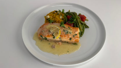 Freshly seared Salmon with lemon velouté paired with turmeric rice with pickled garlic and seasoned green beans with diced tomatoes